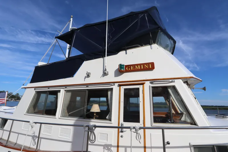 Slide: The Image of 1993 Grand Banks 46 Classic yacht "Gemini" with blue canopy, docked under clear sky. - 7