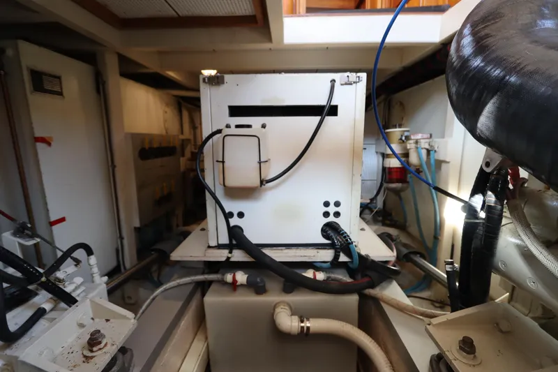 Slide: The Image of Engine room of 1993 Grand Banks 46 Classic yacht, featuring mechanical equipment and piping. - 86