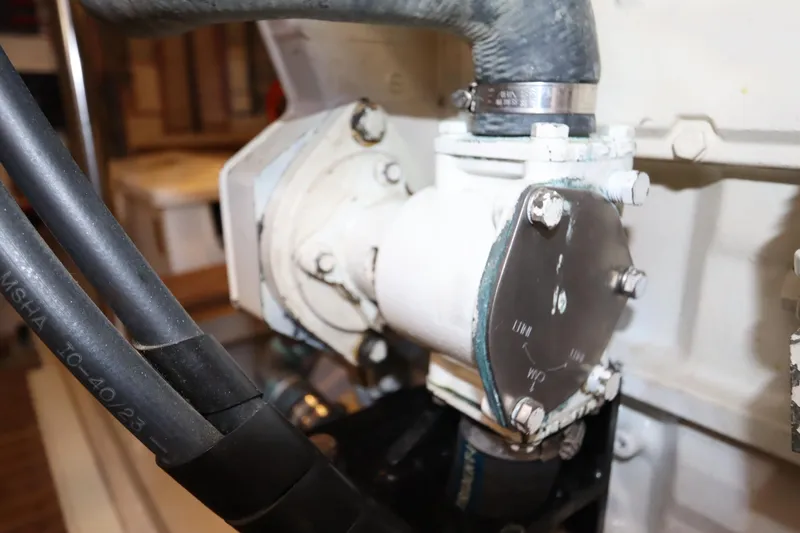 Slide: The Image of Engine component of 1993 Grand Banks 46 Classic yacht, featuring hoses and metal fittings. - 93