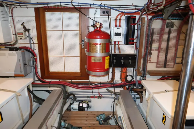 Slide: The Image of Engine room of a 1993 Grand Banks 46 Classic with fire extinguisher and wiring. - 95