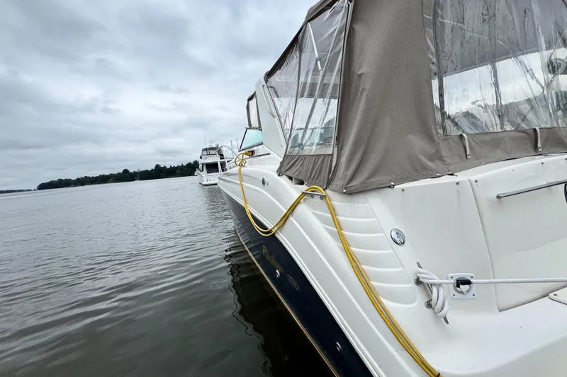 Slide: The Image of 2005 Rinker Fiesta Vee 342 boat docked on a calm, cloudy day. - 10