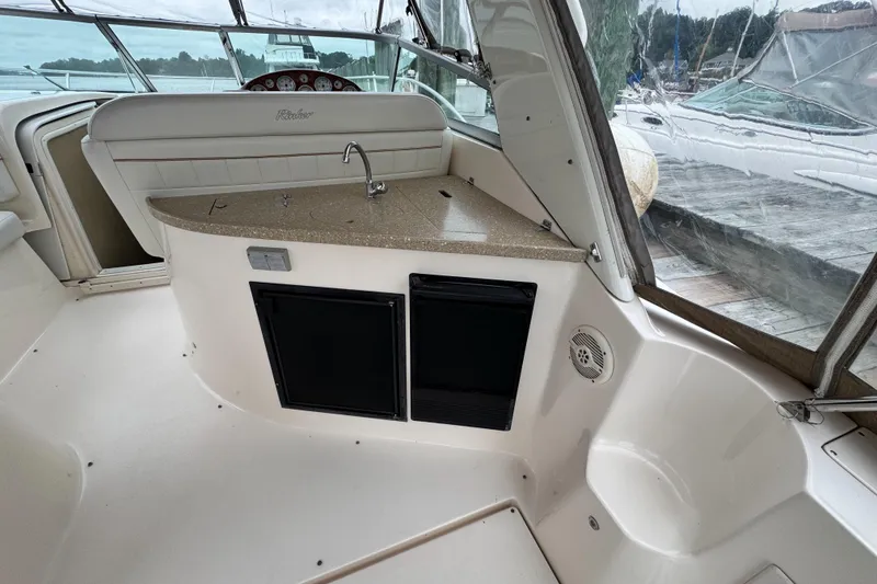 Slide: The Image of 2005 Rinker Fiesta Vee 342 boat interior with kitchenette and seating area. - 13