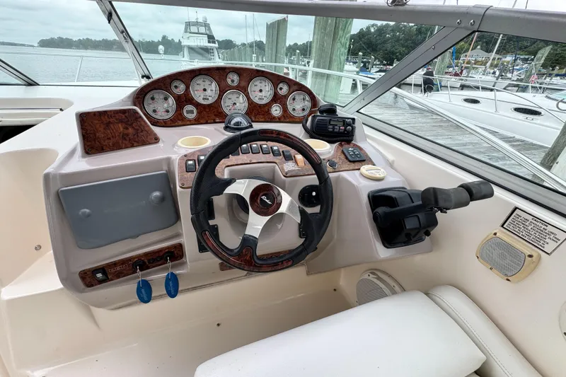 Slide: The Image of 2005 Rinker Fiesta Vee 342 helm with steering wheel, gauges, and controls at marina. - 17