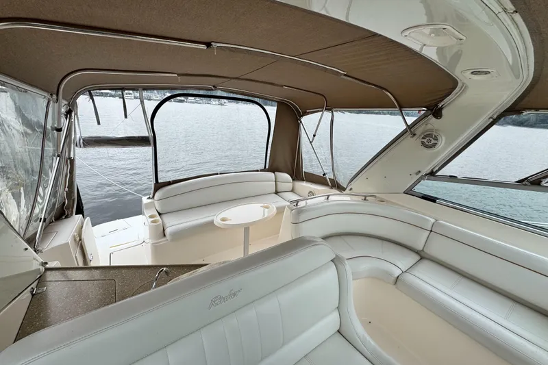 Slide: The Image of 2005 Rinker Fiesta Vee 342 boat interior with white seating and lake view. - 19