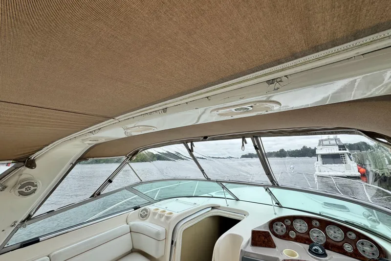 Slide: The Image of 2005 Rinker Fiesta Vee 342 boat interior with dashboard and canopy, docked by the water. - 20