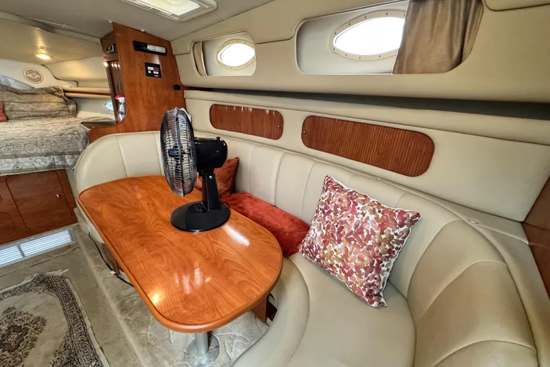 Slide: The Image of 2005 Rinker Fiesta Vee 342 cabin interior with seating, table, and decorative pillows. - 23