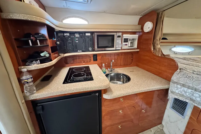 Slide: The Image of 2005 Rinker Fiesta Vee 342 boat kitchen with stove, sink, and microwave. - 25