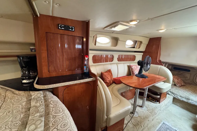 Slide: The Image of 2005 Rinker Fiesta Vee 342 cabin interior with seating, table, and kitchenette. - 27