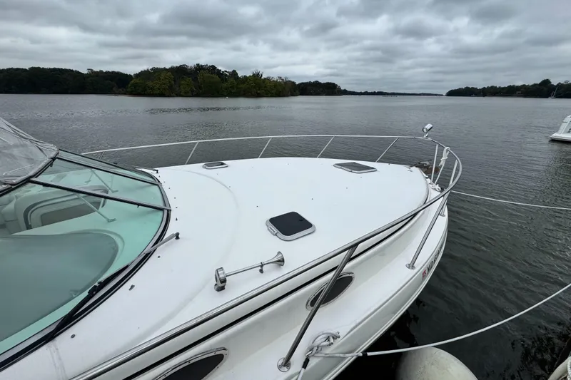 Slide: The Image of 2005 Rinker Fiesta Vee 342 boat docked on a calm lake under cloudy skies. - 4