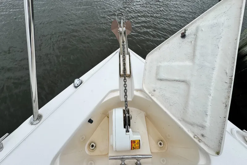 Slide: The Image of 2005 Rinker Fiesta Vee 342 boat anchor compartment with open hatch, showing chain and water background. - 5