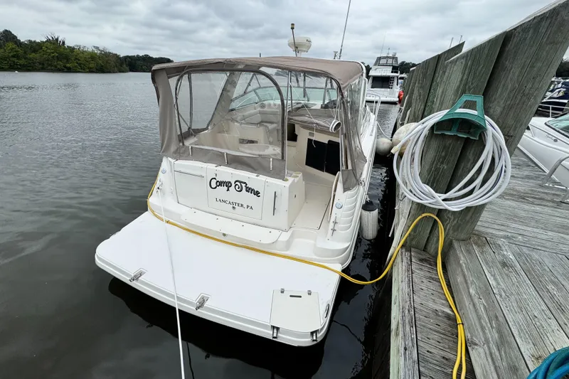Slide: The Image of 2005 Rinker Fiesta Vee 342 docked, featuring a covered cockpit and mooring lines. - 9