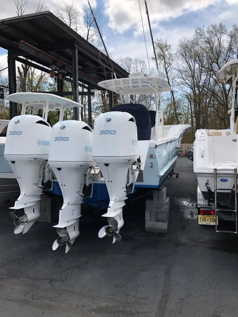 Slide: The Image of 2017 Buddy Davis 34 Center Console boat with triple outboard engines, docked outdoors. - 11