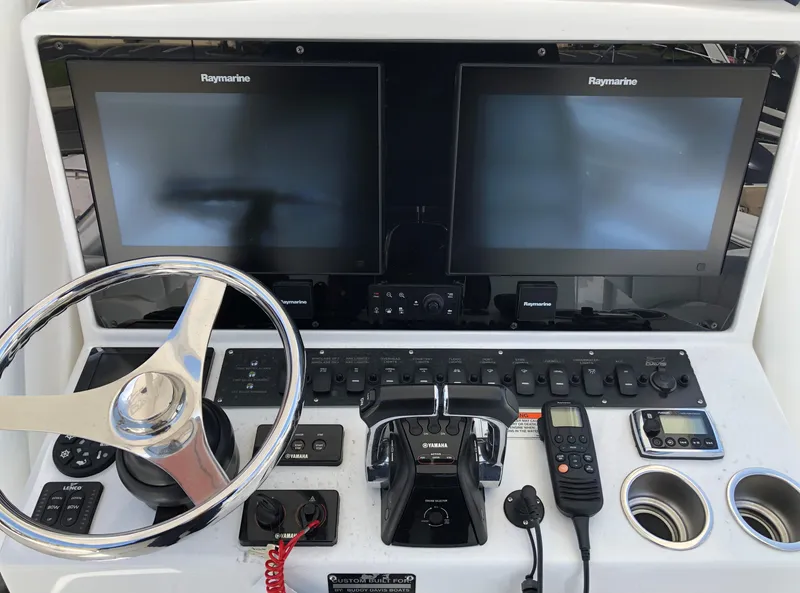Slide: The Image of 2017 Buddy Davis 34 Center Console helm with dual Raymarine displays and controls. - 8