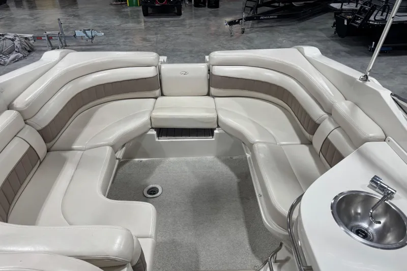 Slide: The Image of Interior of a 1998 Regal 2800 LSR boat with plush seating and a sink. - 9