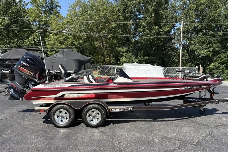 Slide: The Image of 2015 Skeeter ZX225 bass boat with Yamaha engine on trailer, parked outdoors. - 1
