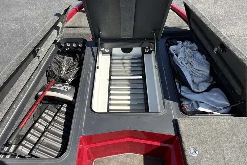 Slide: The Image of 2015 Skeeter ZX225 boat storage compartments with fishing gear and clothing. - 7