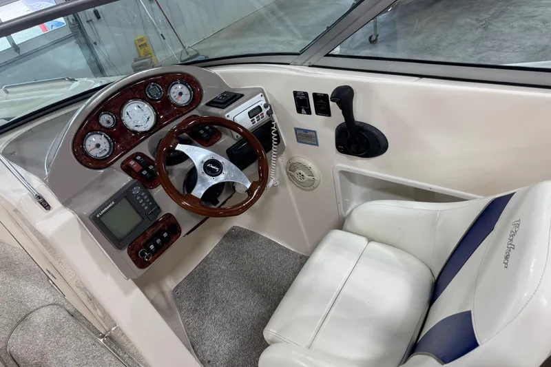 Slide: The Image of 2004 Rinker 282 Captiva Bowrider cockpit with steering wheel and control panel. - 11