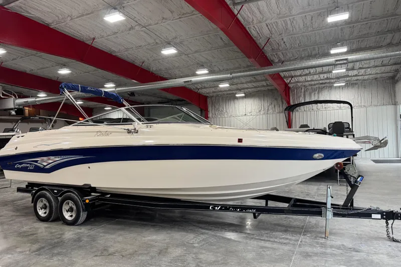 Slide: The Image of 2004 Rinker 282 Captiva Bowrider boat on trailer in indoor storage facility. - 2