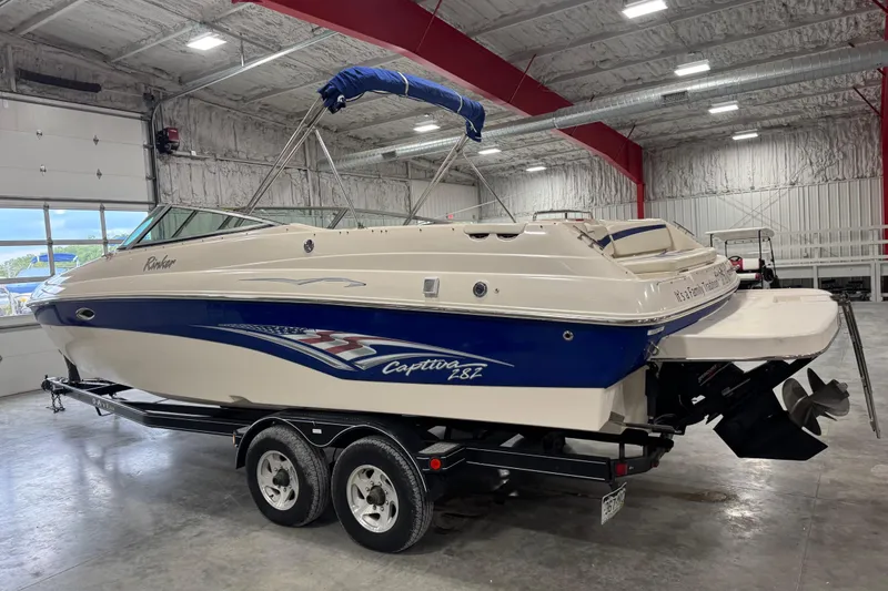 Slide: The Image of 2004 Rinker 282 Captiva Bowrider boat in indoor storage, on a trailer. - 3