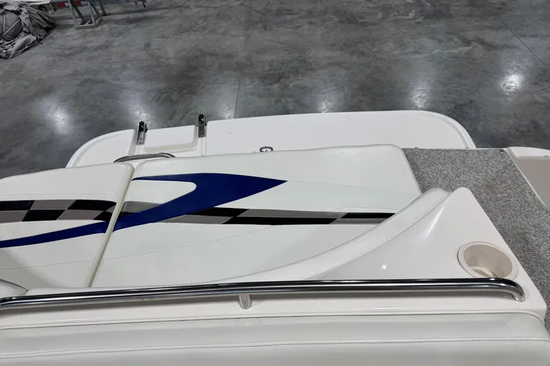 Slide: The Image of 2004 Rinker 282 Captiva Bowrider interior with white and blue seating, stainless steel rail. - 5