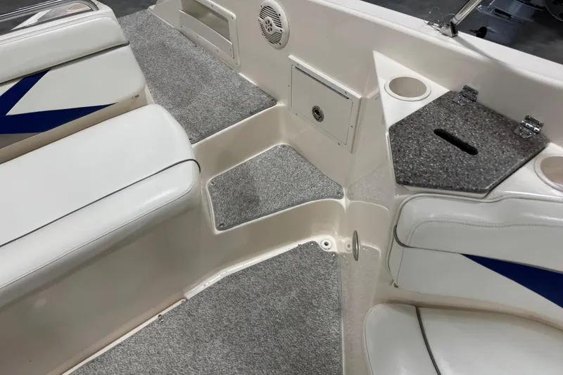 Slide: The Image of 2004 Rinker 282 Captiva Bowrider interior with white seating and carpeted flooring. - 7