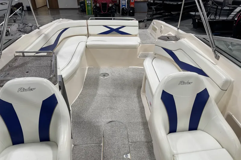 Slide: The Image of 2004 Rinker 282 Captiva Bowrider interior with white and blue seating, spacious layout. - 9