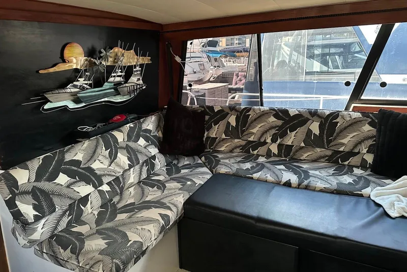 Slide: The Image of 1994 Bayliner 3888 Motoryacht interior with patterned seating and nautical wall art. - 13