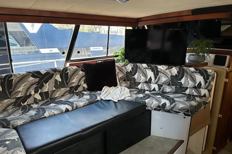 Slide: The Image of 1994 Bayliner 3888 Motoryacht interior with patterned seating and a flat-screen TV. - 14