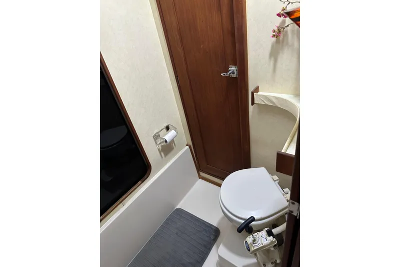 Slide: The Image of 1994 Bayliner 3888 Motoryacht bathroom with toilet, wooden door, and window. - 17