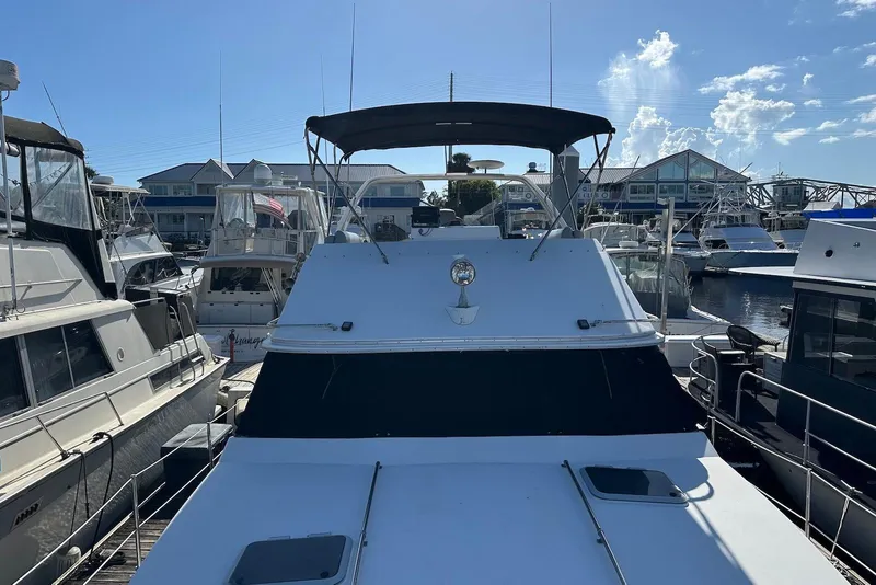 Slide: The Image of 1994 Bayliner 3888 Motoryacht docked at marina under clear blue sky. - 22