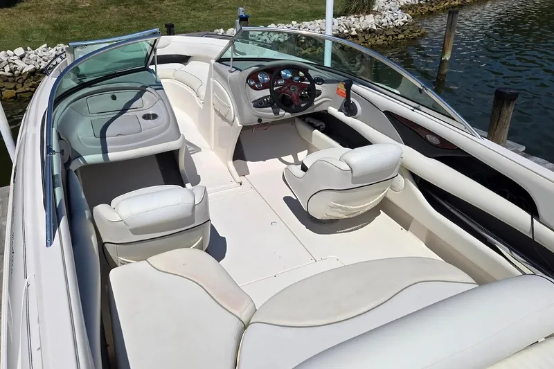 Slide: The Image of 2003 Monterey 228SI Montura Bowrider with white interior, docked by a lake. - 10