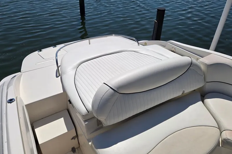 Slide: The Image of 2003 Monterey 228SI Montura Bowrider with white seating, docked on calm water. - 14