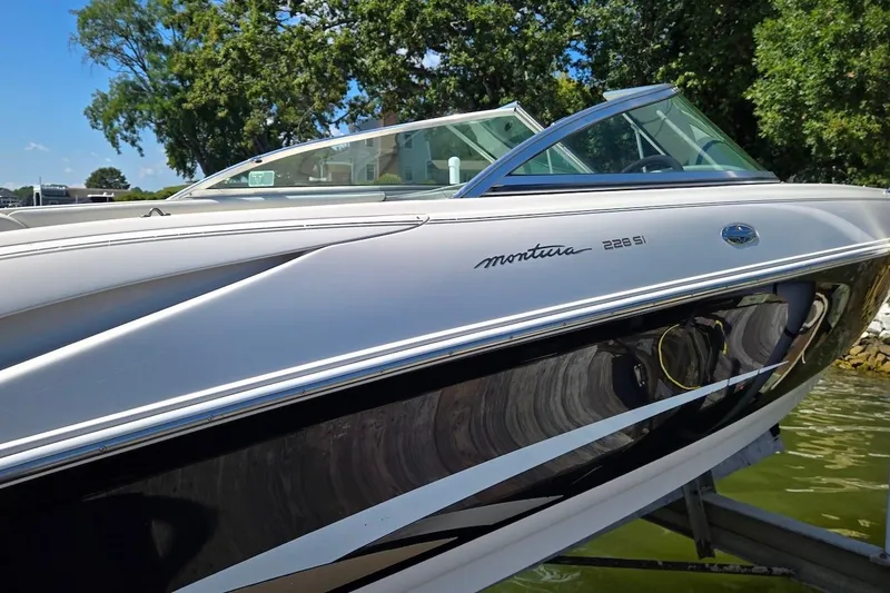 Slide: The Image of 2003 Monterey 228SI Montura Bowrider boat on water, side view with trees in background. - 4