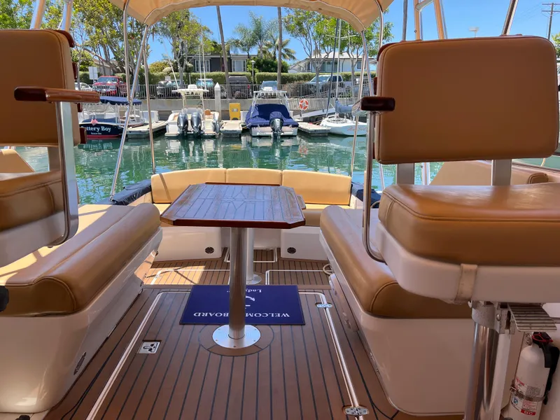Slide: The Image of 2001 Legacy Yachts 28 Express interior with seating and table, docked at a marina. - 14