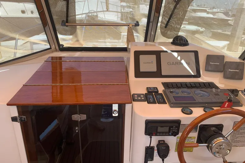Slide: The Image of 2001 Legacy Yachts 28 Express helm with Garmin navigation system and wooden steering wheel. - 16
