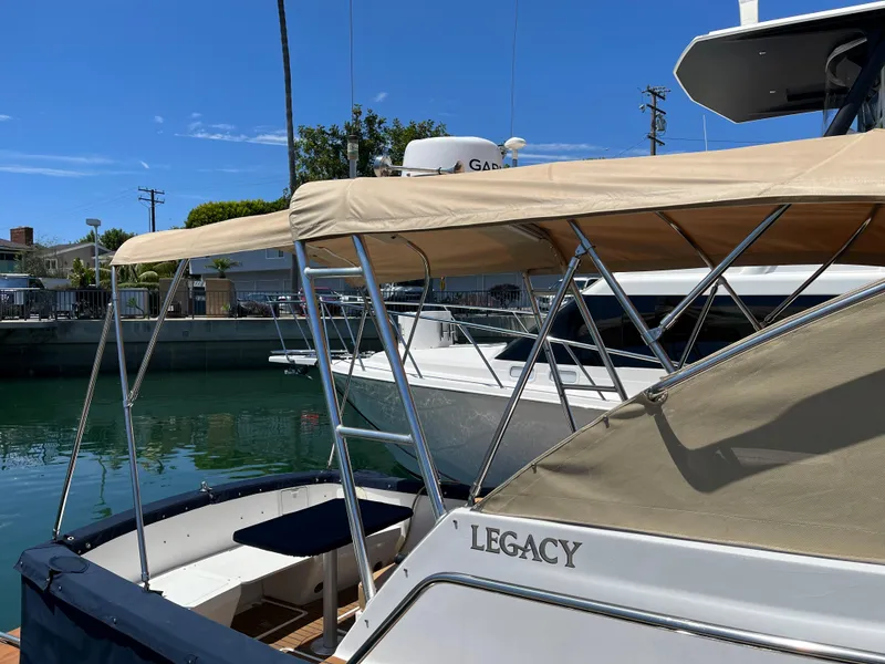 Slide: The Image of 2001 Legacy Yachts 28 Express docked, featuring beige canopy and sleek design. - 20