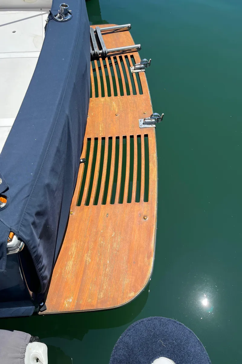 Slide: The Image of 2001 Legacy Yachts 28 Express swim platform with wooden slats and blue cover. - 24