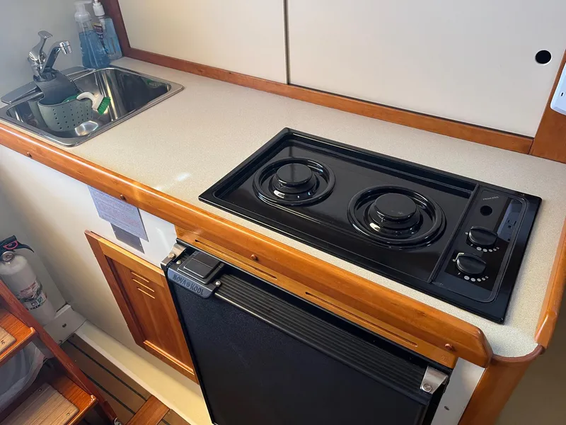 Slide: The Image of Compact kitchen area in a 2001 Legacy Yachts 28 Express with stove and sink. - 3
