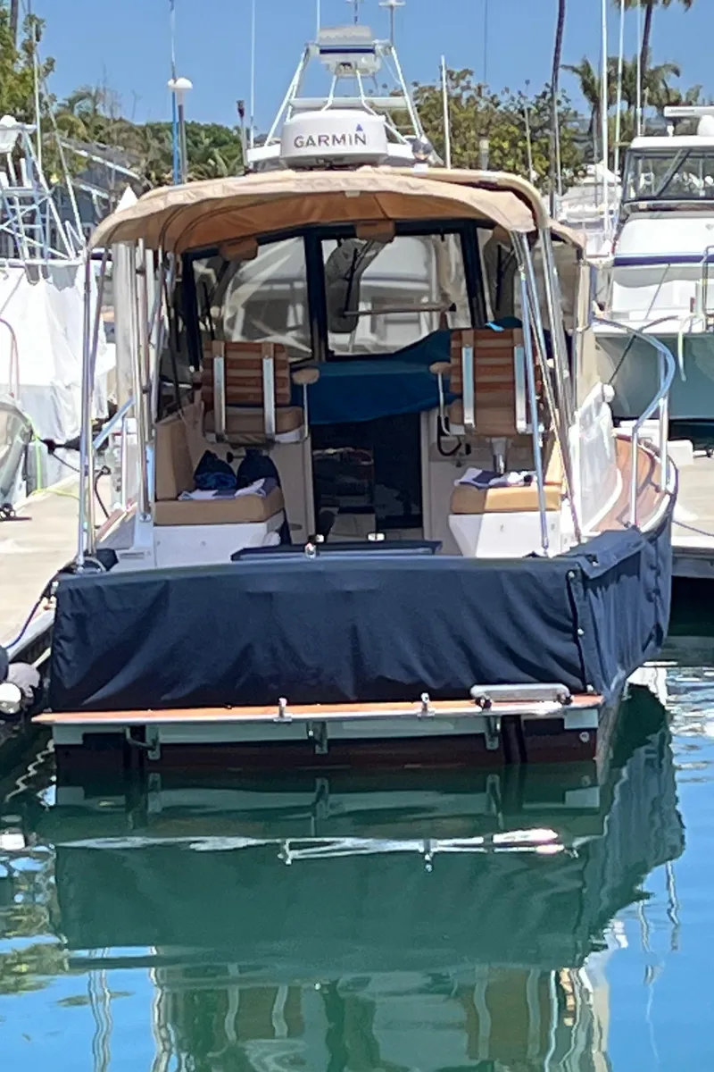 Slide: The Image of 2001 Legacy Yachts 28 Express docked, featuring a covered seating area and sleek design. - 30