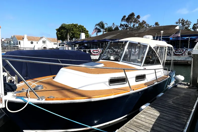 Slide: The Image of 2001 Legacy Yachts 28 Express docked in a marina, featuring a blue hull and tan canopy. - 35