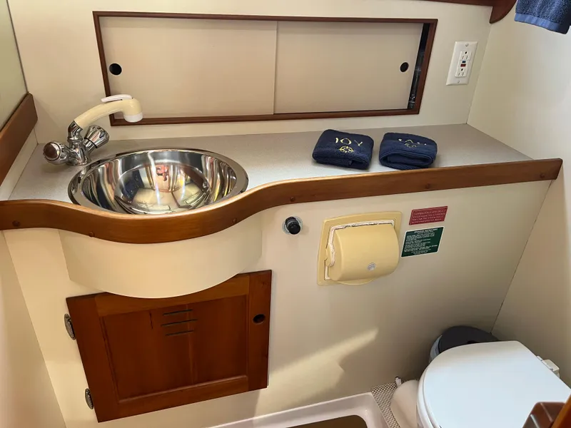 Slide: The Image of 2001 Legacy Yachts 28 Express bathroom with stainless steel sink and wooden cabinetry. - 6