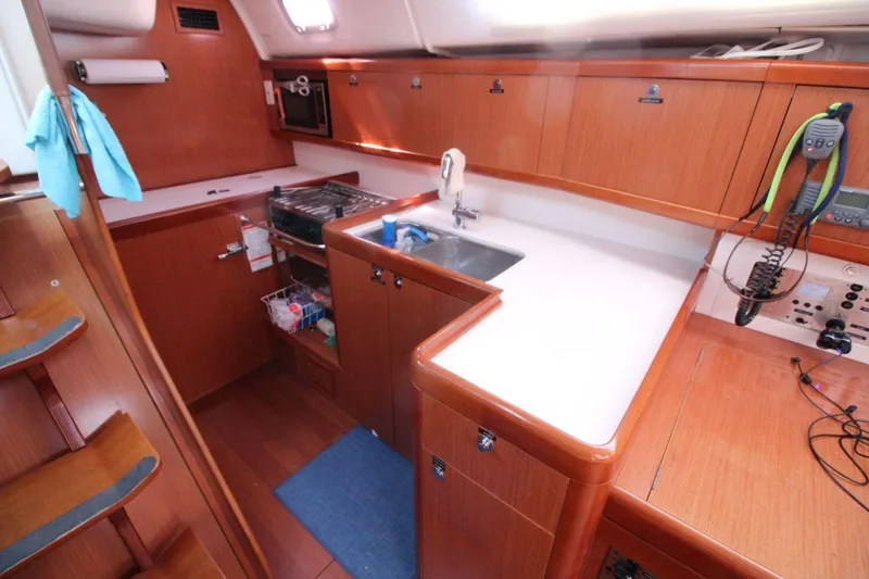 Slide: The Image of 2016 Beneteau Oceanis 40 yacht interior kitchen with wooden cabinetry and modern appliances. - 11
