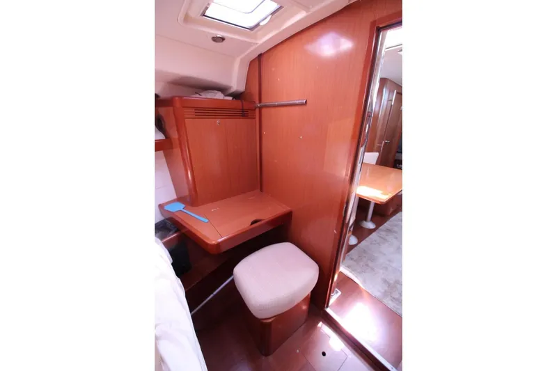 Slide: The Image of Interior of 2016 Beneteau Oceanis 40 yacht with wooden desk and cushioned stool. - 14
