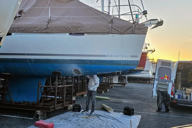 Slide: The Image of 2016 Beneteau Oceanis 40 sailboat undergoing maintenance at a marina during sunset. - 22