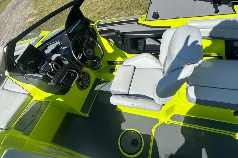 Slide: The Image of 2023 Axis A225 boat interior with bright yellow accents and modern steering console. - 5