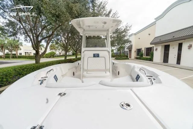 Slide: The Image of 2026 Sea Fox 228 Commander boat, white interior, parked outdoors near buildings and trees. - 13