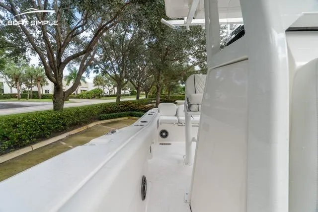 Slide: The Image of 2026 Sea Fox 228 Commander boat interior with seating, surrounded by lush greenery. - 21