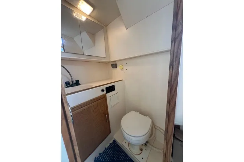 Slide: The Image of 1998 Henriques 28 Express boat bathroom with sink, mirror, and toilet. - 10