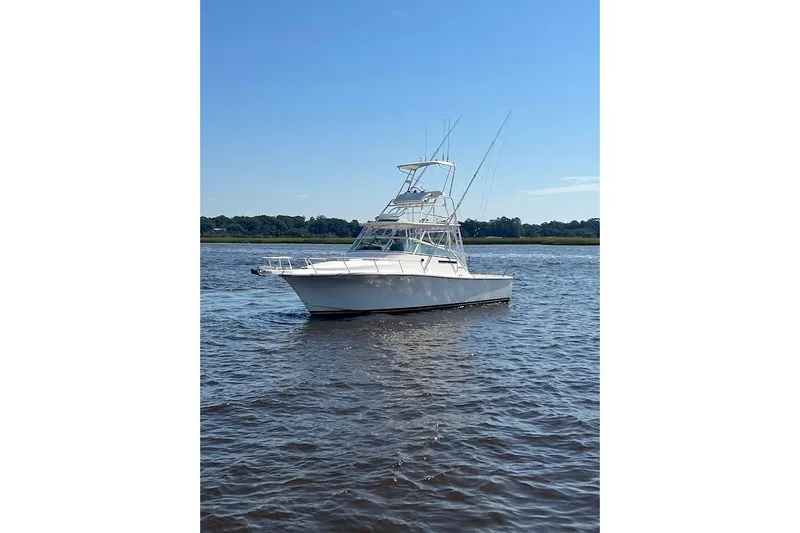 Slide: The Image of 1998 Henriques 28 Express boat on calm water under clear blue sky. - 2
