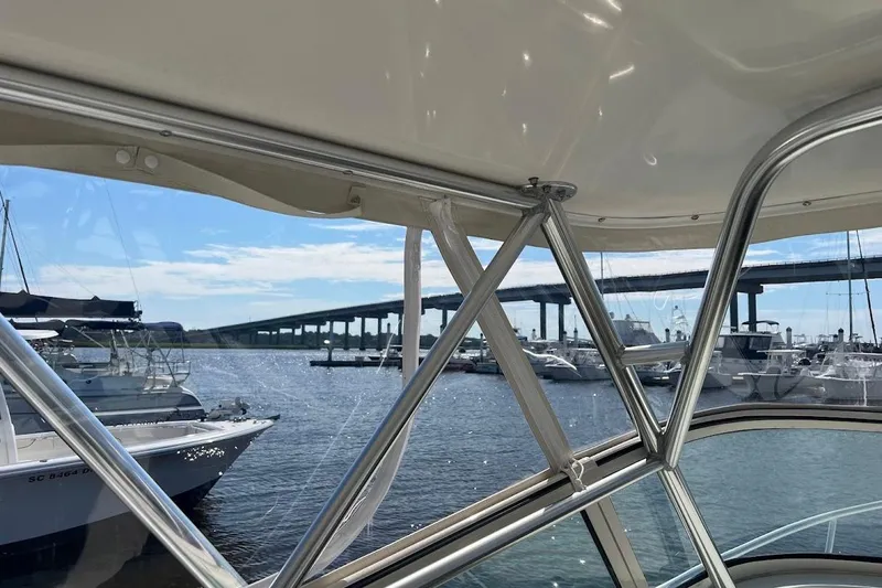 Slide: The Image of 1998 Henriques 28 Express boat view with marina and bridge in the background. - 3